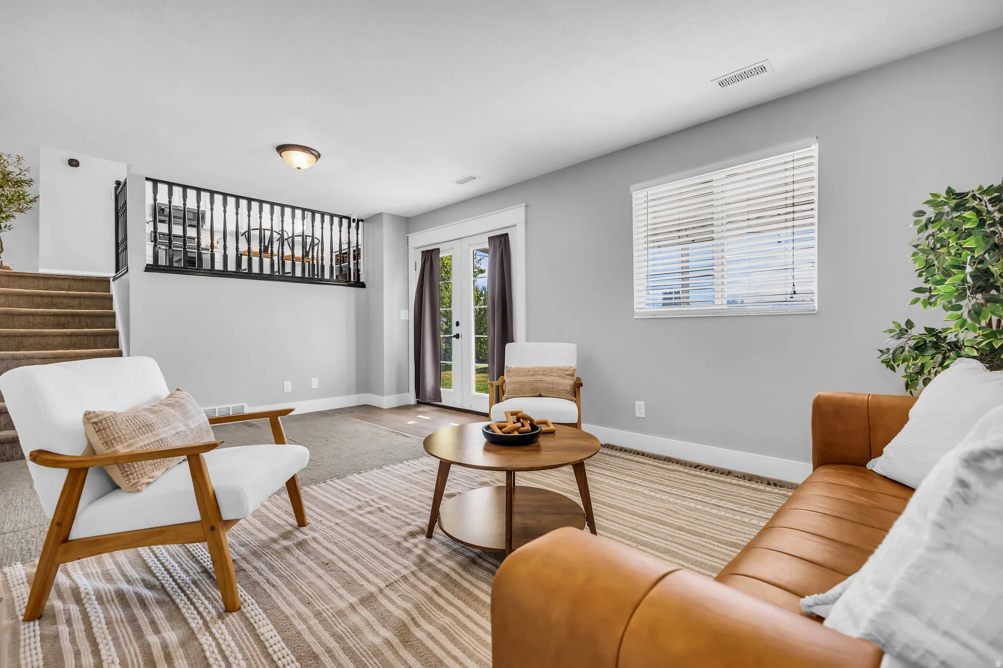 Carpeted flooring, light grey wall paint, white trim, recessed lighting, and a double-door exterior entry