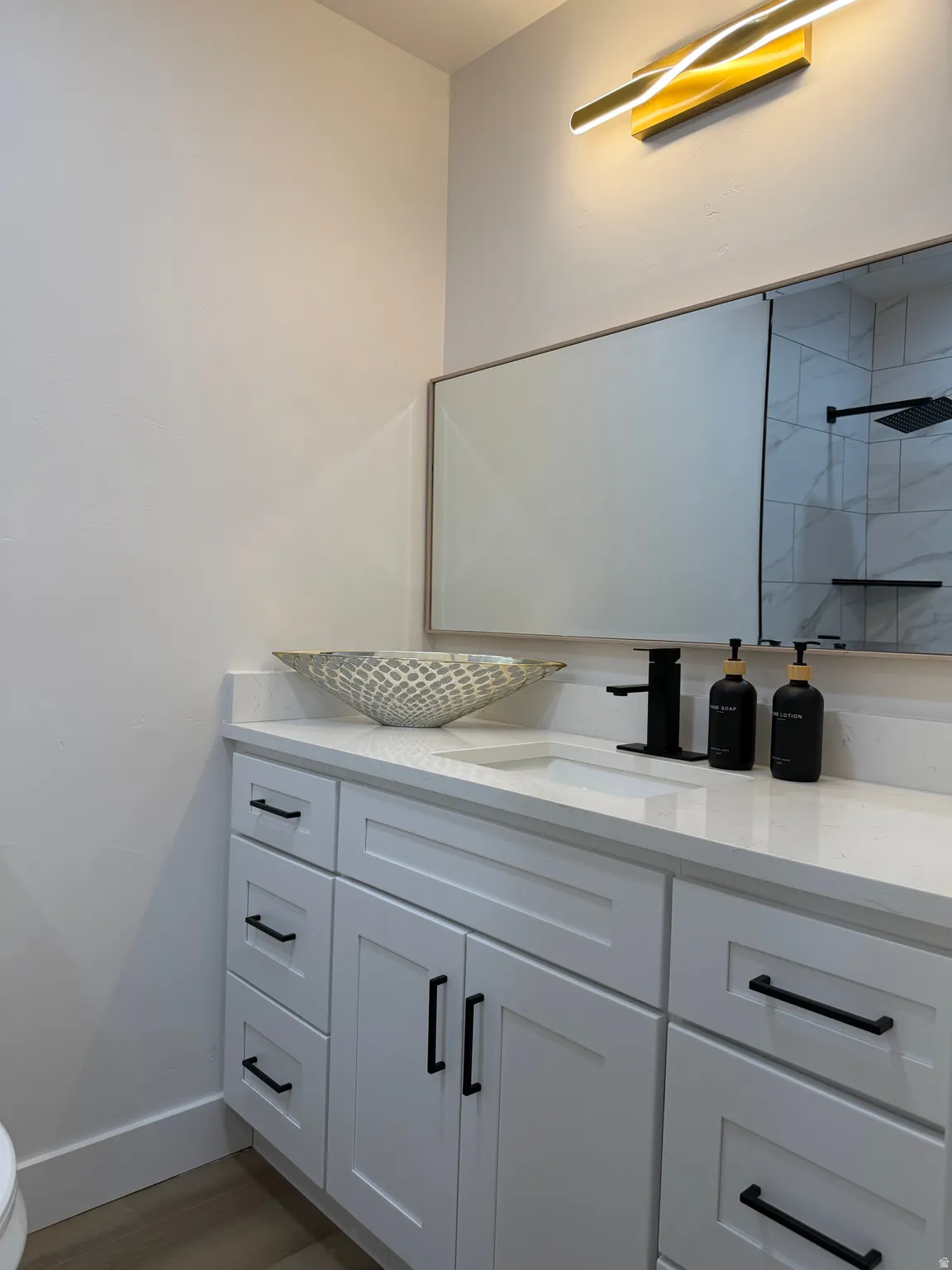 White shaker cabinetry with black hardware, integrated sink, and a countertop