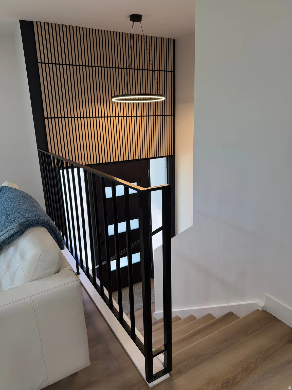 Linear wood-finish accent wall with a modern pendant light
