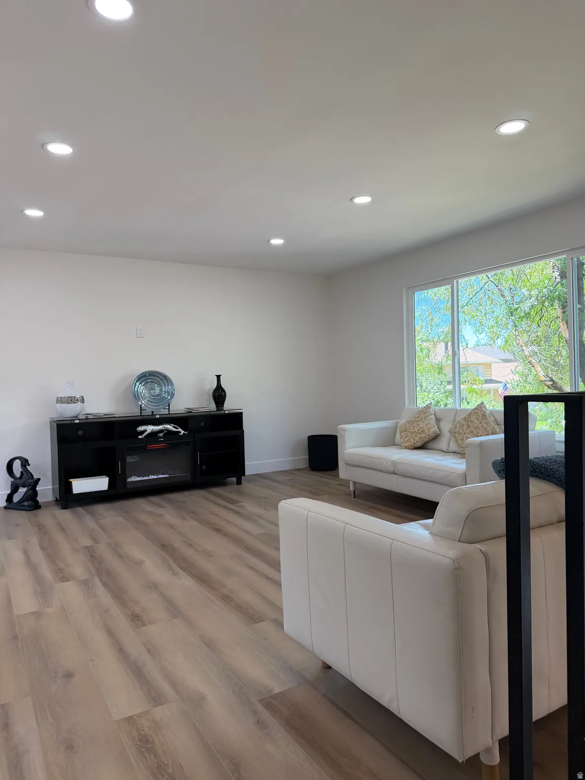 Recessed lighting, wood-finish flooring, white walls, and large windows