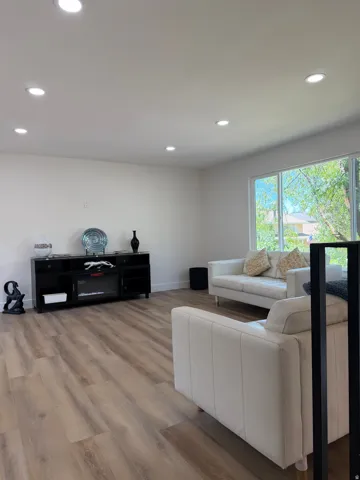 Recessed lighting, wood-finish flooring, white walls, and large windows