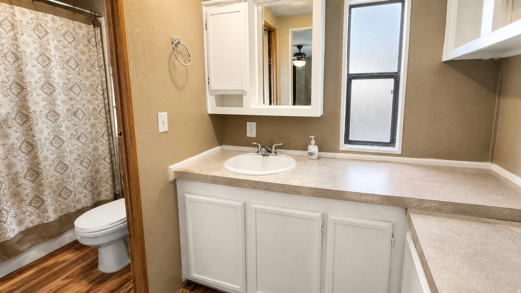 Primary Bathroom with a white vanity, integrated sink, and ample countertop space