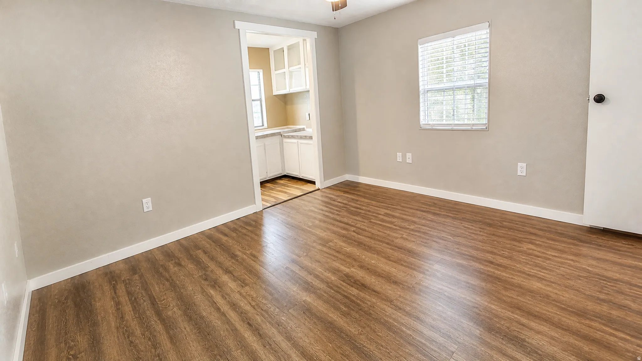 Wood-finish flooring throughout, neutral wall tones, and white trim