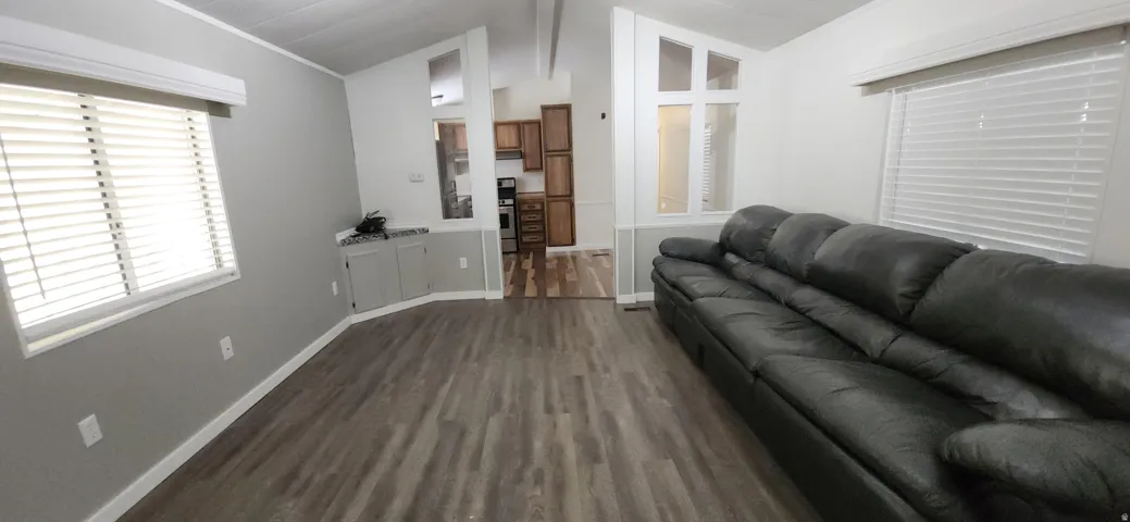 Vaulted ceiling, wood-finish flooring, two large windows with blinds, built-in lower cabinetry with countertop