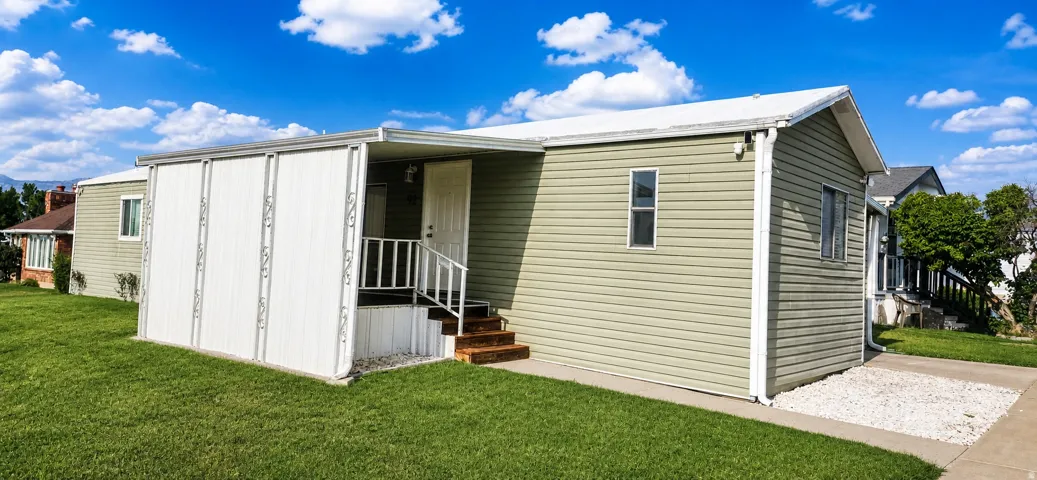 Light green siding exterior with white trim and a white roof