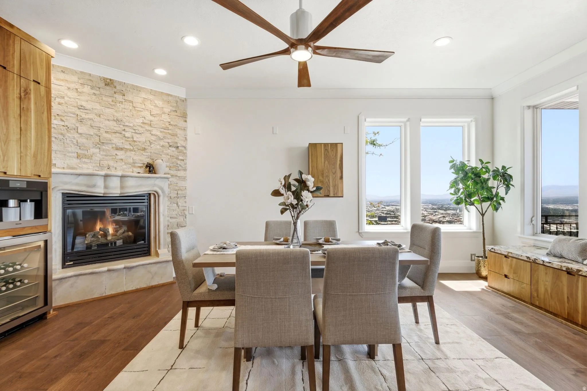 Wood-finish flooring, recessed lighting, and a stone-clad fireplace with a carved mantel