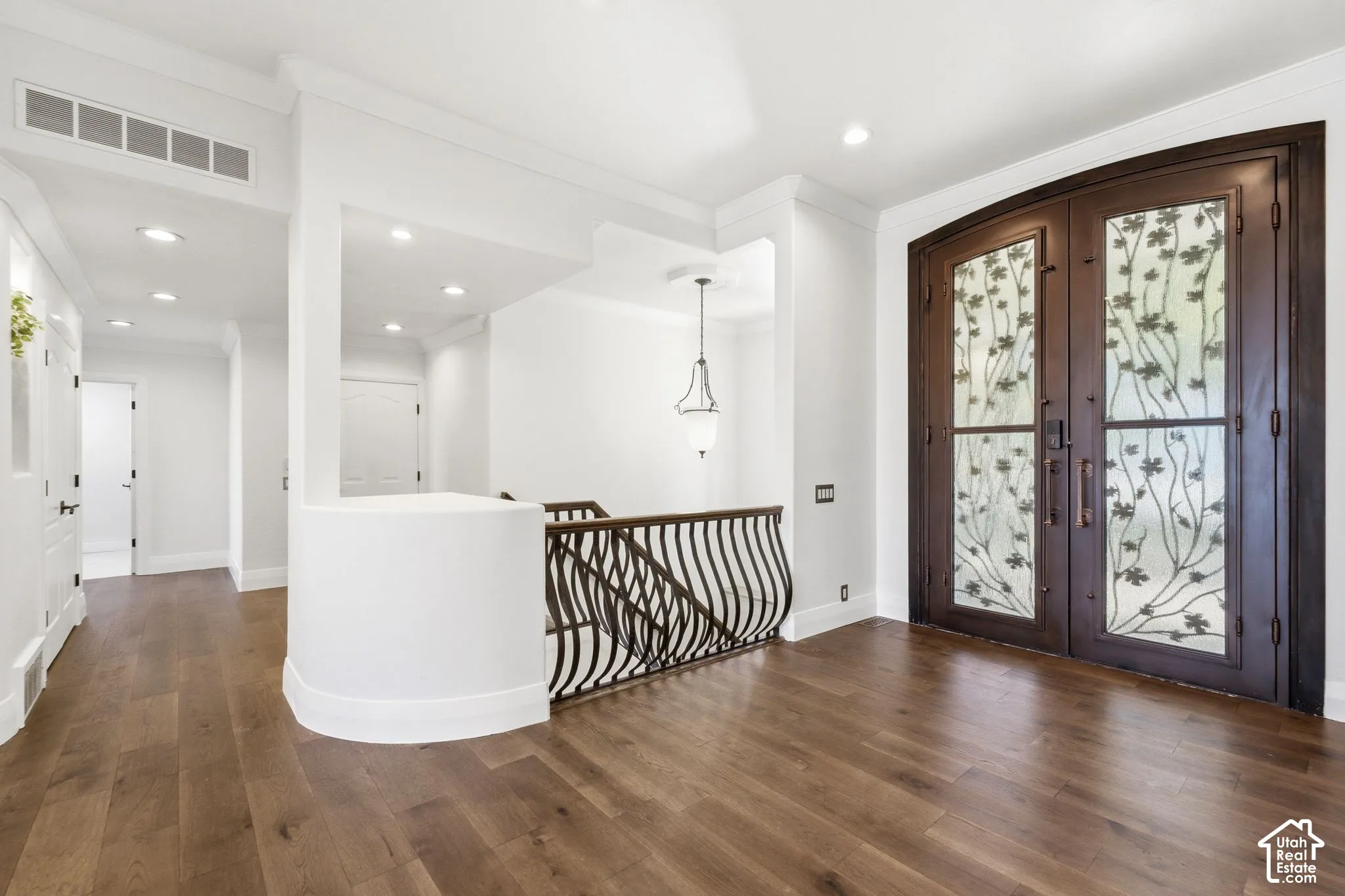 Wood-finish flooring, recessed lighting, and crown molding