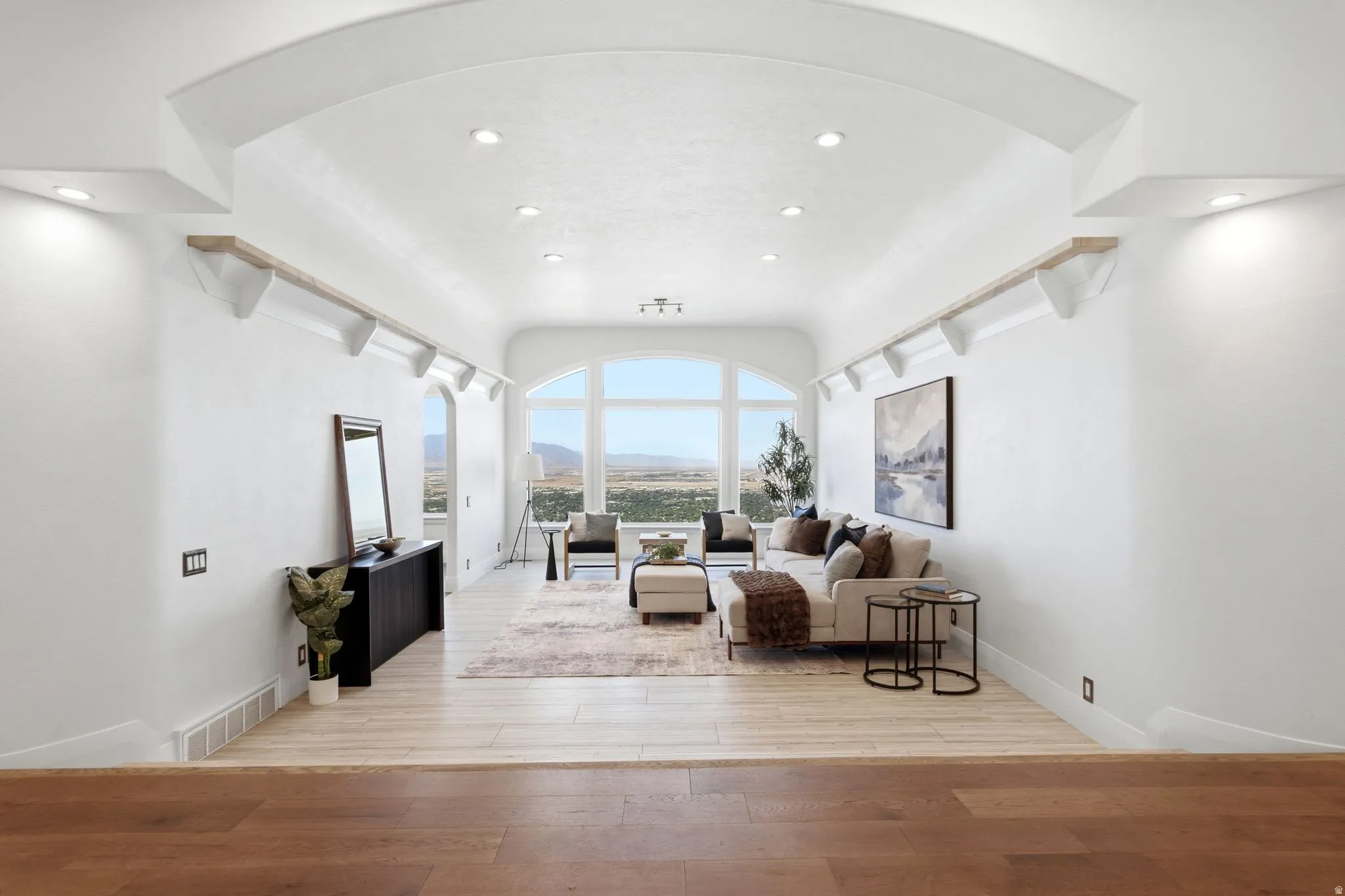 Archway entrance with recessed lighting and built-in shelving, wood-finish flooring, and expansive arched windows