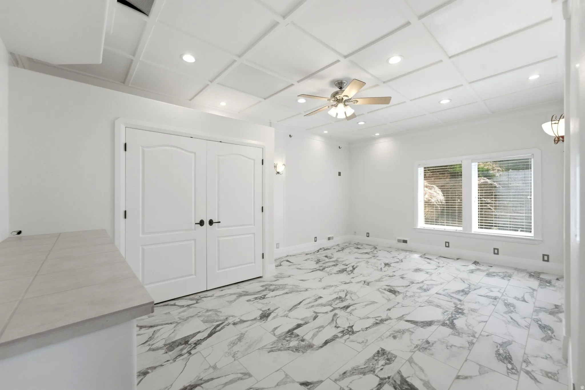 Coffered ceiling with recessed lighting and a ceiling fan