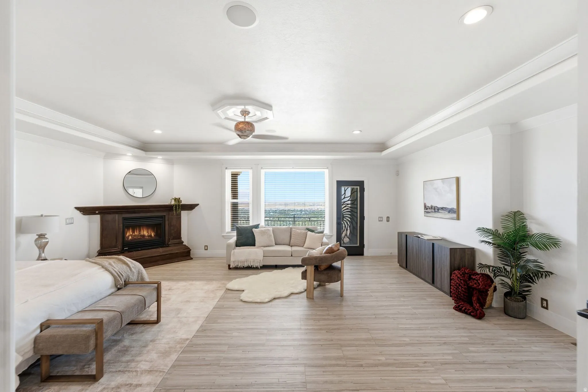 Wood-finish flooring, recessed lighting, ceiling fan, fireplace with wood mantel, and tray ceiling
