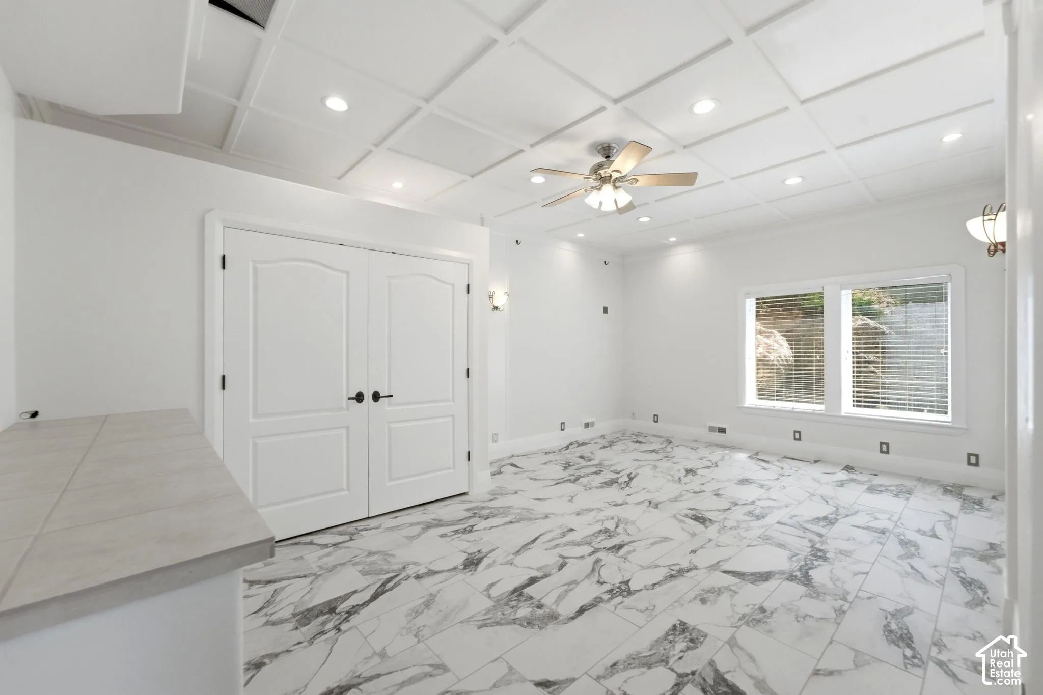 Coffered ceiling with recessed lighting and a ceiling fan