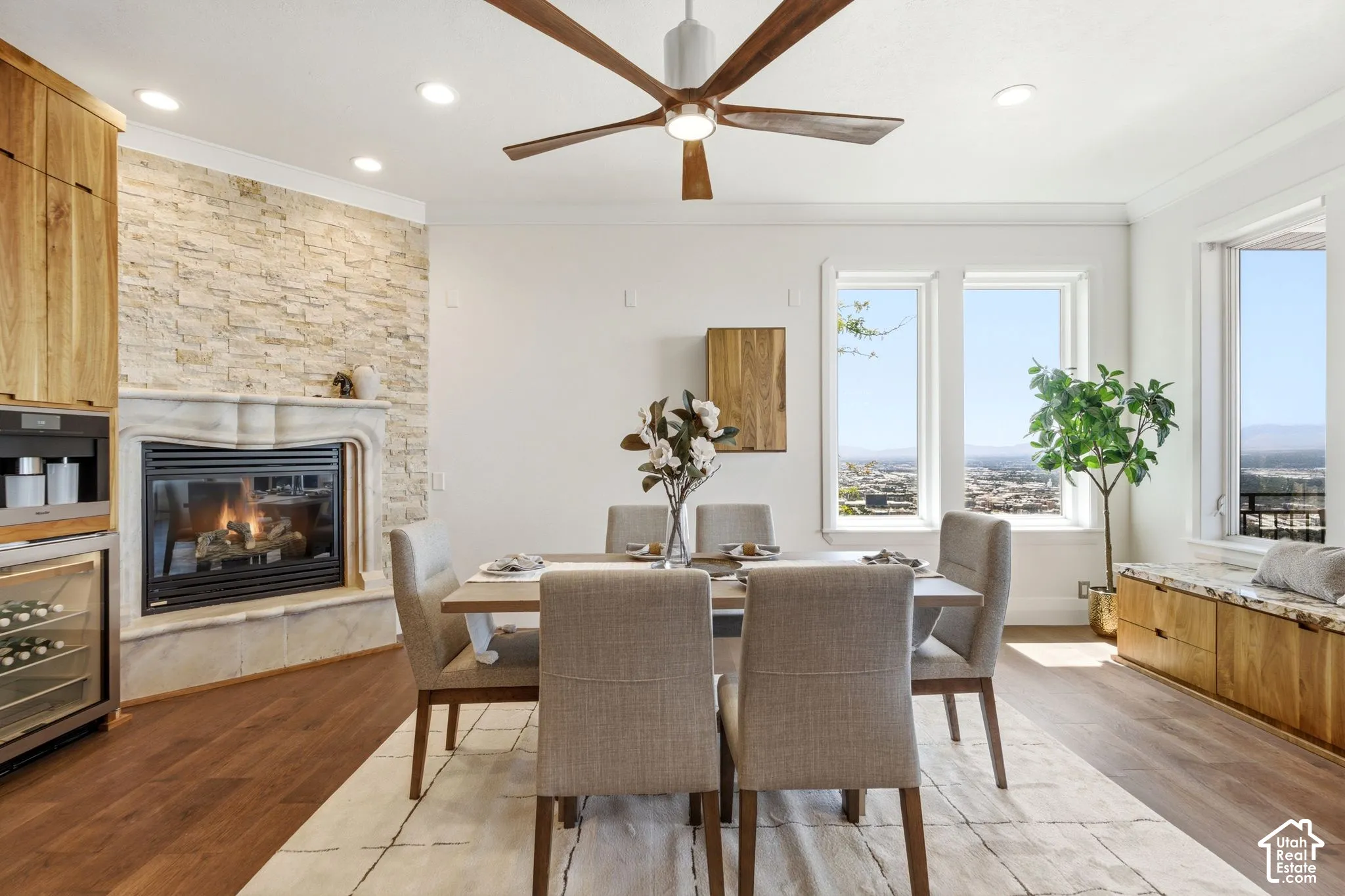 Wood-finish flooring, recessed lighting, and a stone-clad fireplace with a carved mantel