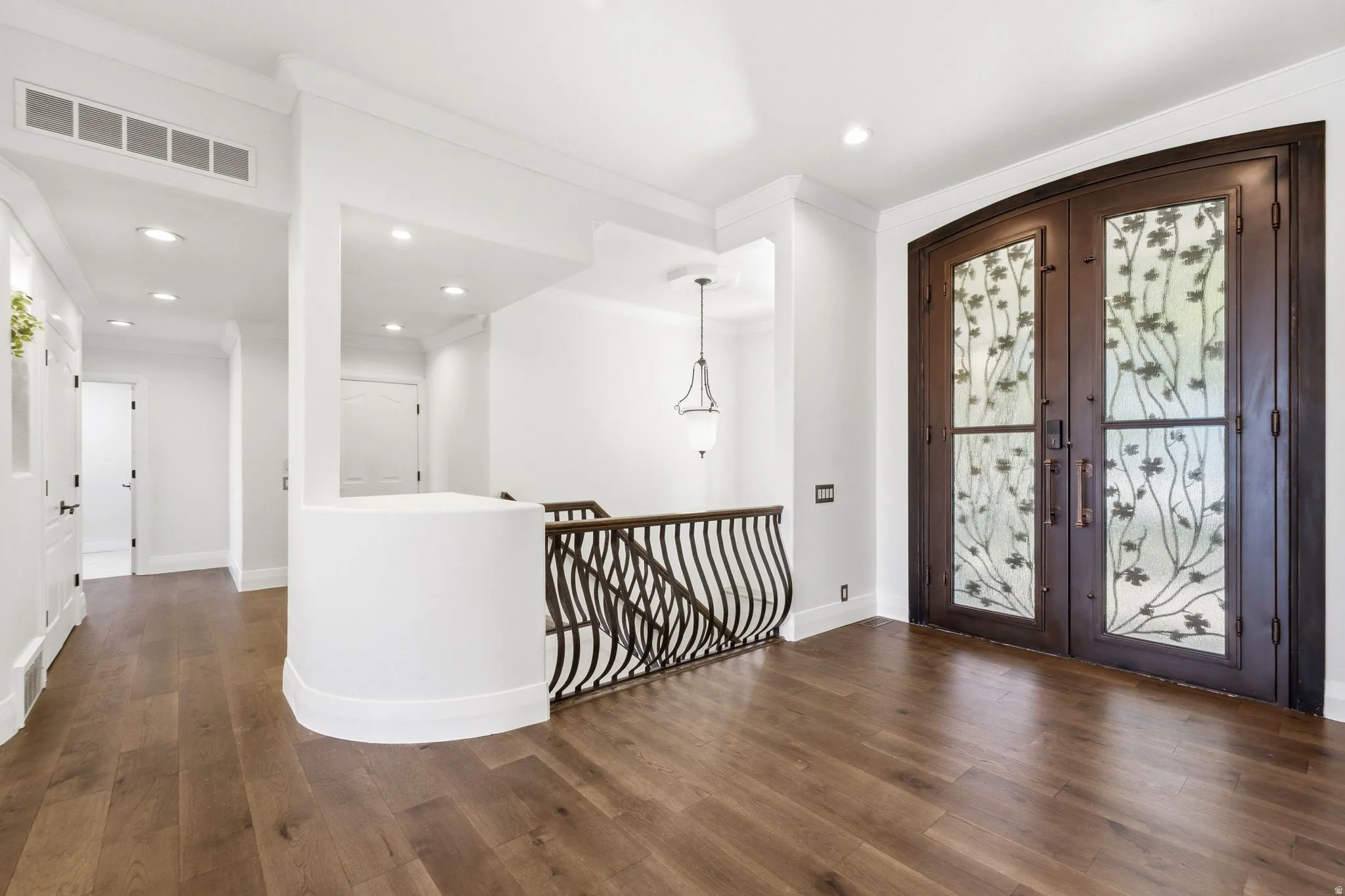 Wood-finish flooring, recessed lighting, and crown molding