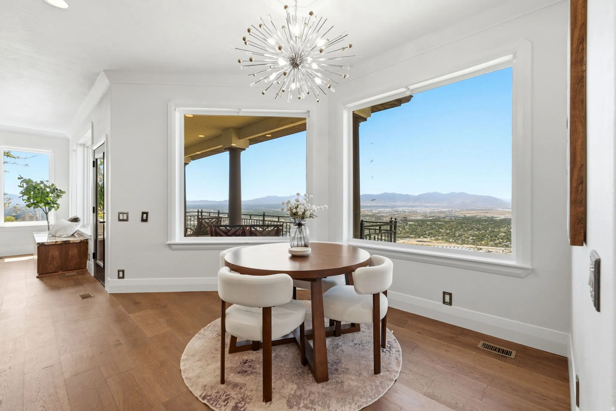 Hardwood-style flooring, white trim, and a modern sputnik chandelier