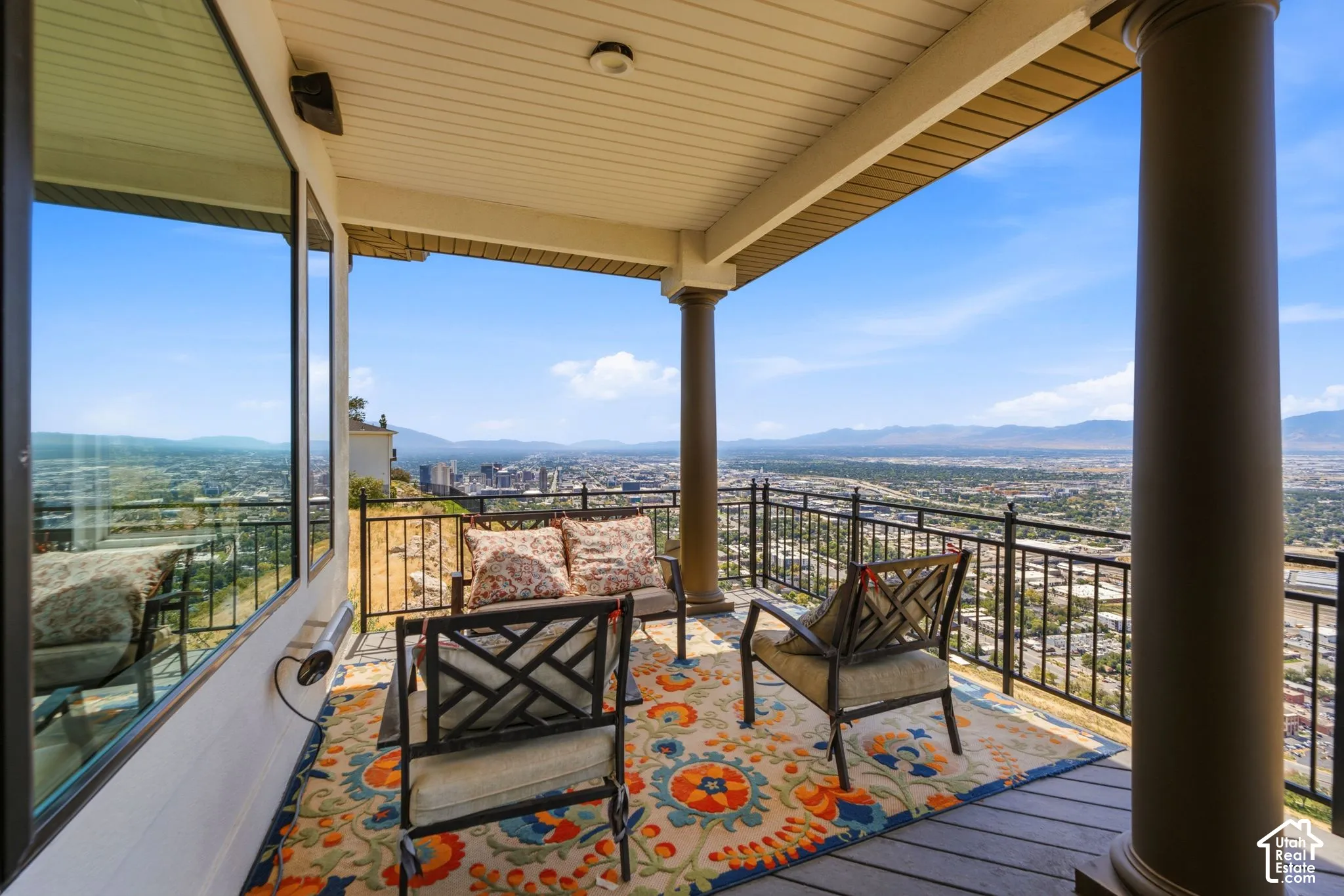 Expansive covered balcony featuring a durable deck surface, robust support pillars, and decorative wrought iron railing