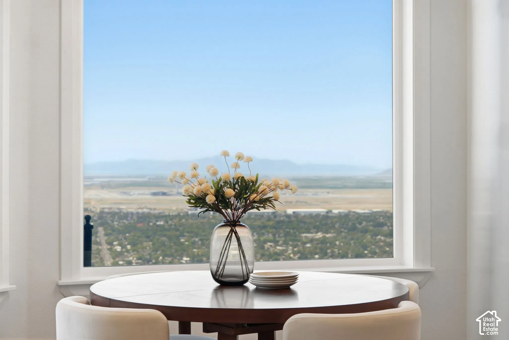 Expansive window with white trim framing a distant mountain and city backdrop