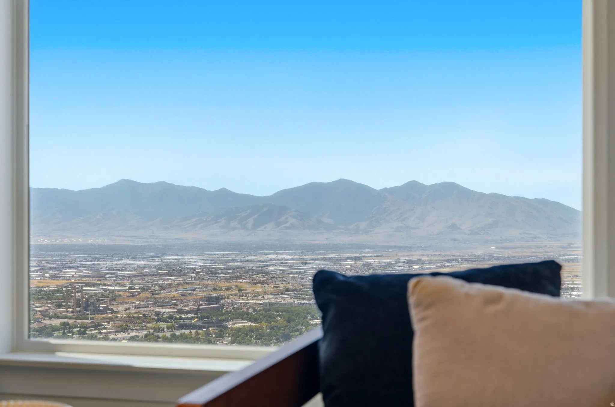 Panoramic city and mountain scenery framed by a large window