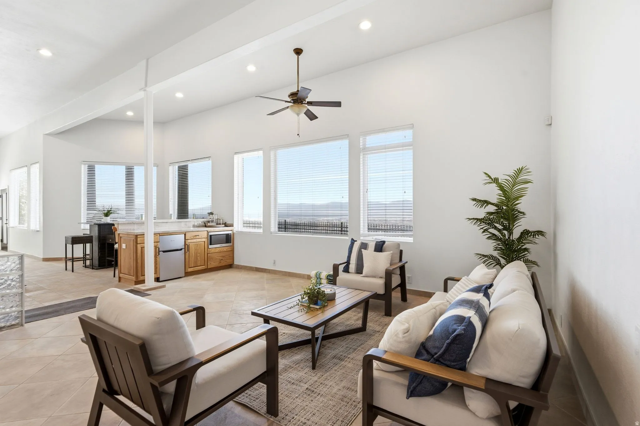 Expansive room with high ceilings, recessed lighting, and a ceiling fan