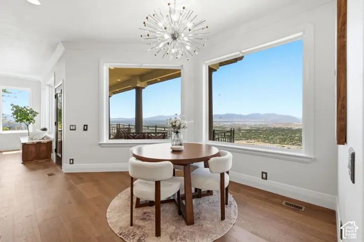 Hardwood-style flooring, white trim, and a modern sputnik chandelier