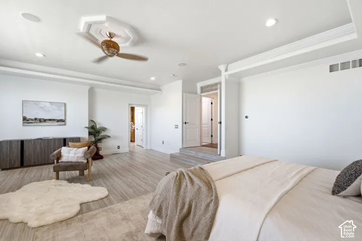 Recessed lighting, wood-finish flooring, ceiling fan with decorative medallion, white paneled doors, and a built-in credenza