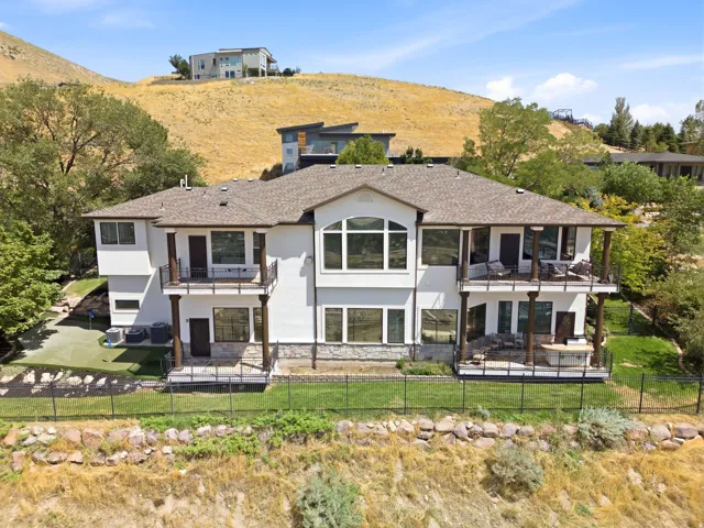 Multi-level exterior with multiple balconies, a lower-level patio, and a putting green