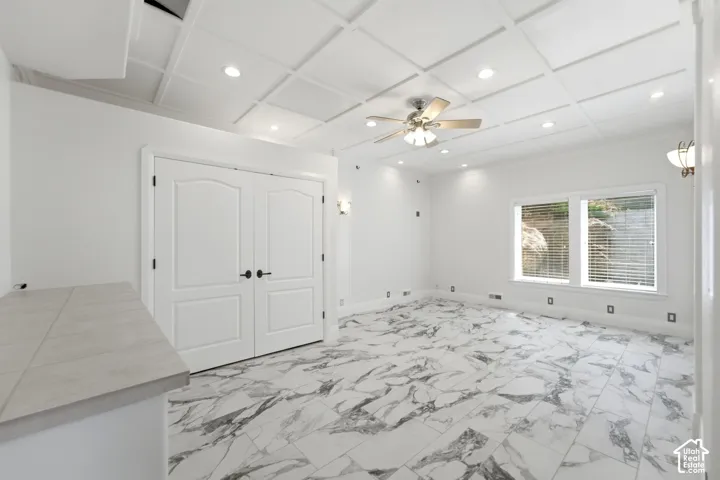 Coffered ceiling with recessed lighting and a ceiling fan