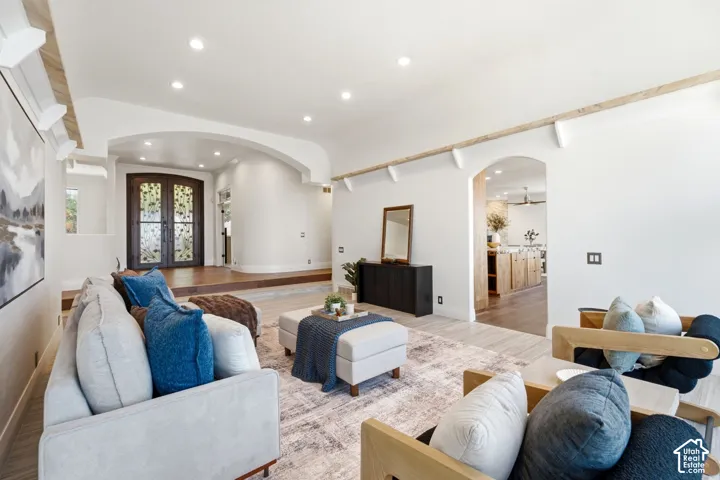 Arched entryways, recessed lighting, wood-finish flooring, and decorative wood ceiling beams