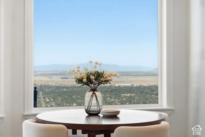 Expansive window with white trim framing a distant mountain and city backdrop