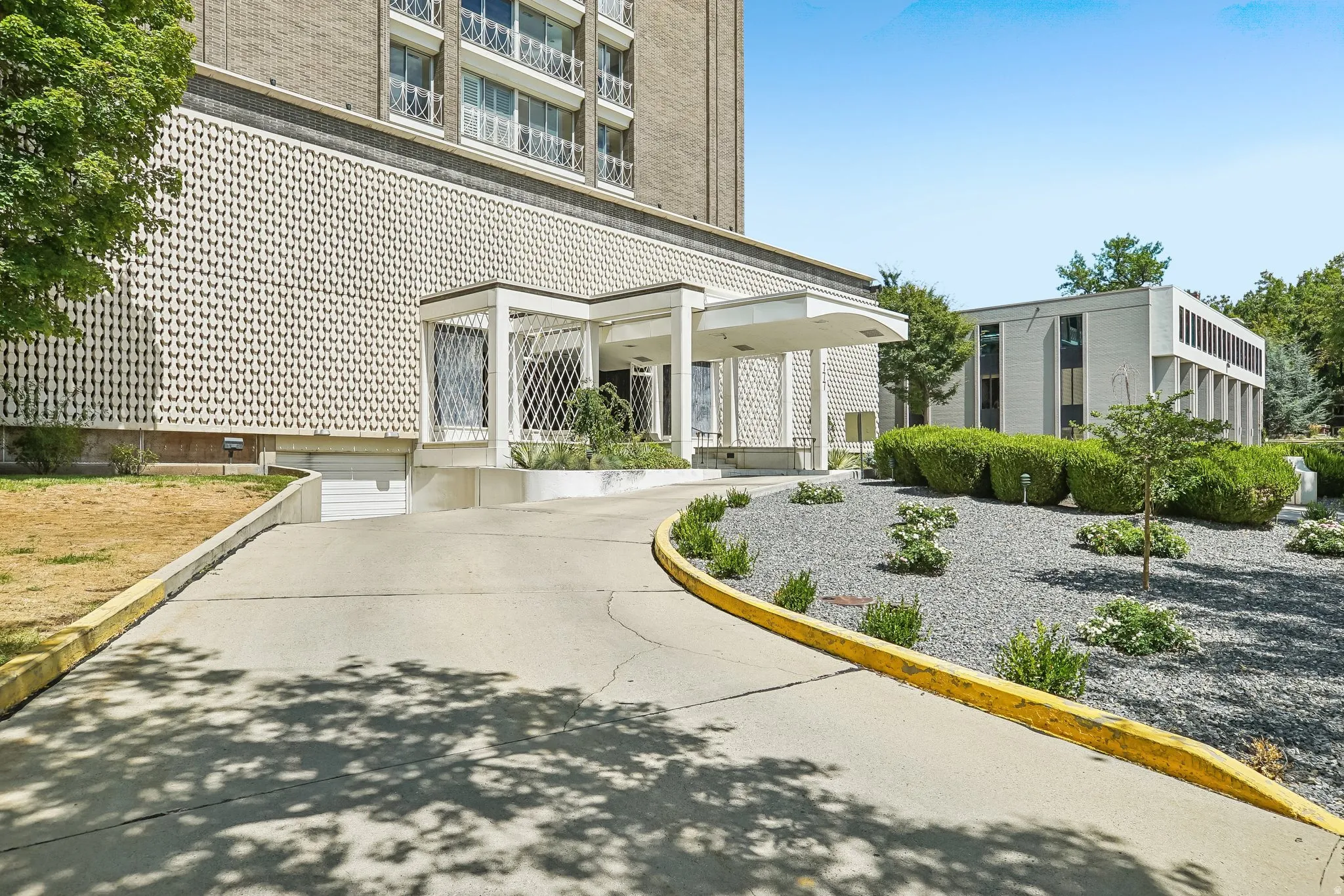Building exterior featuring a covered entryway, decorative facade, and a paved driveway