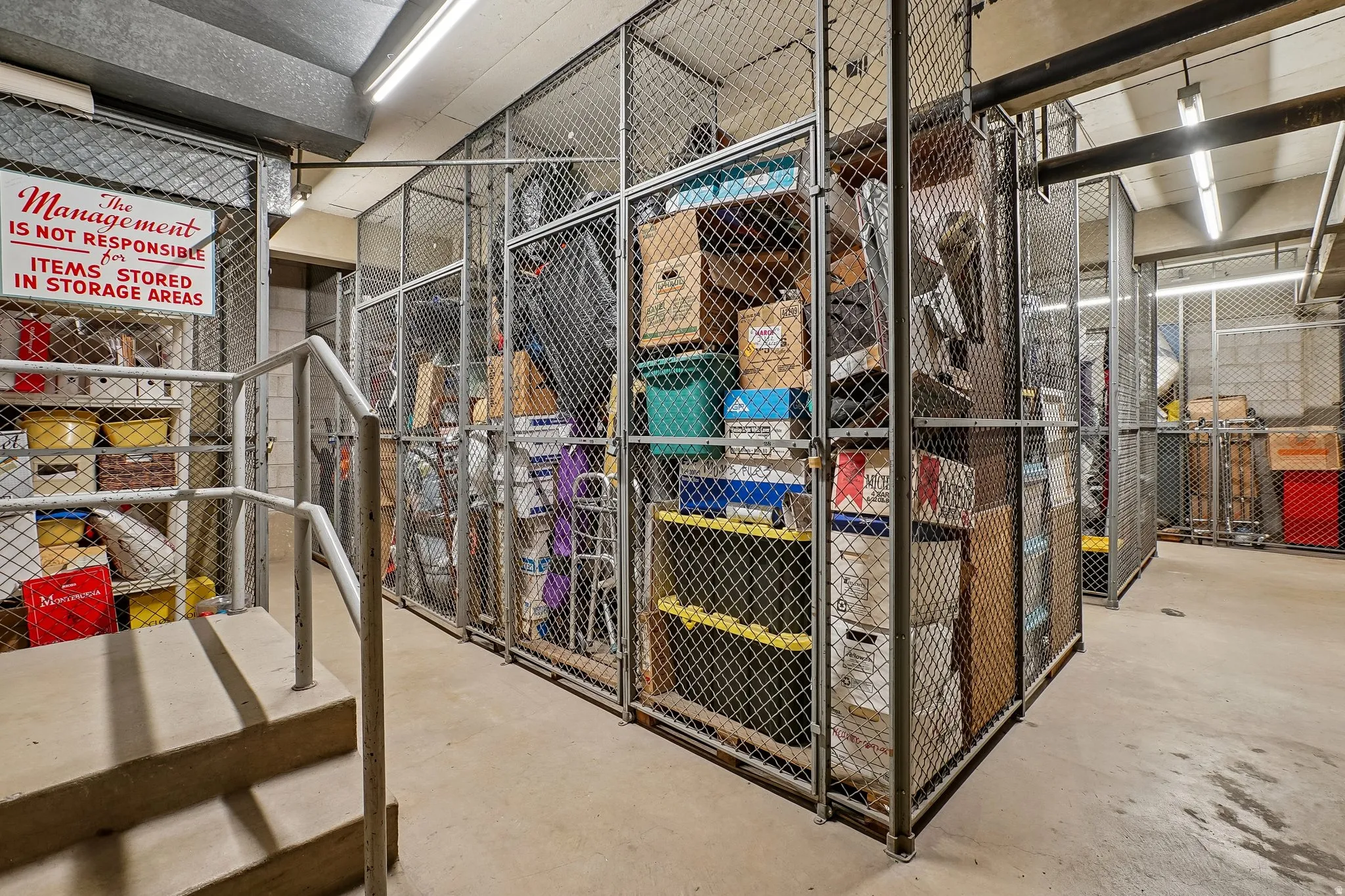 Individual storage lockers with mesh metal construction and concrete flooring