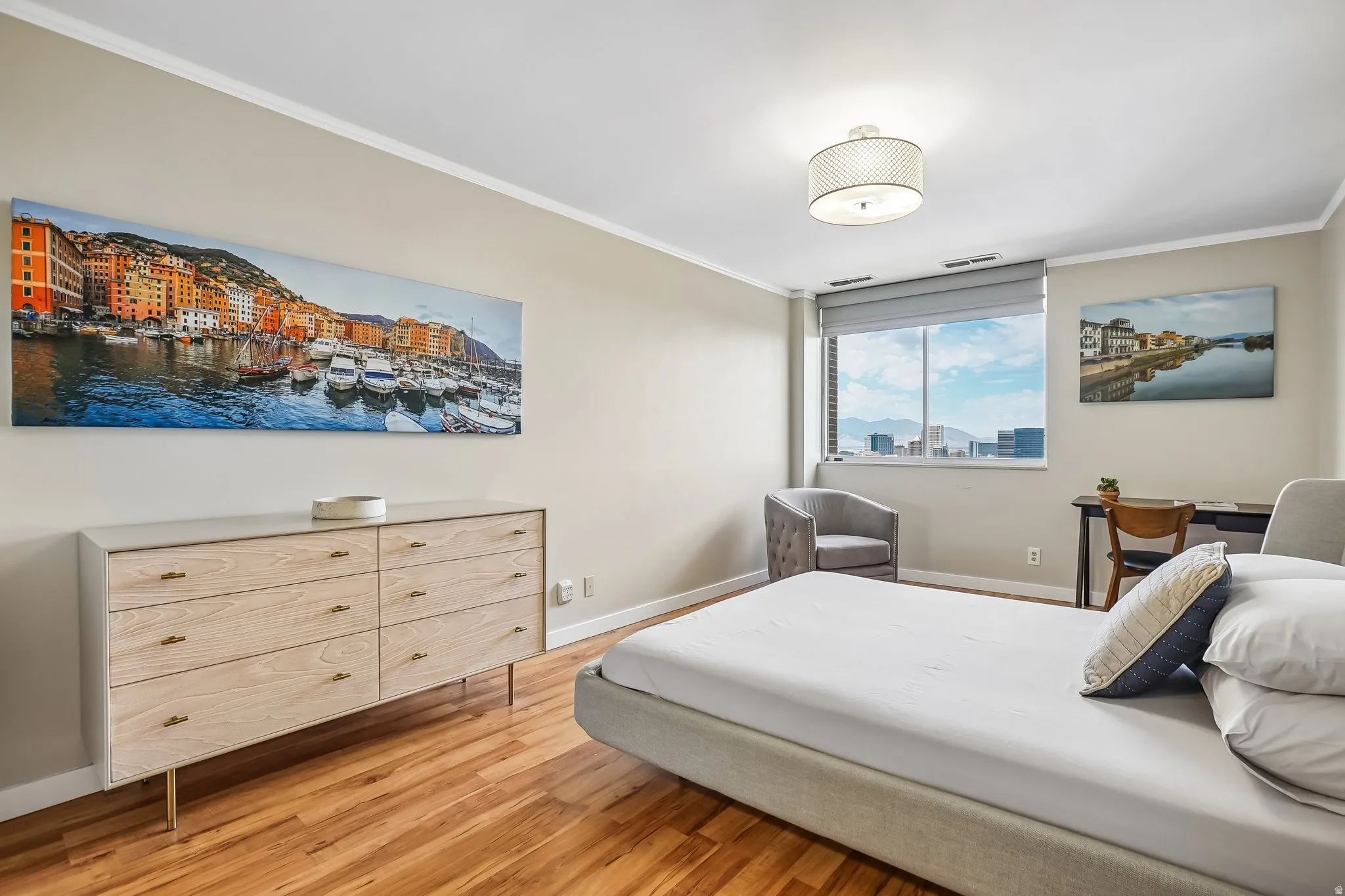 Hardwood flooring, crown molding, large window, drum pendant light fixture, and light neutral wall finishes