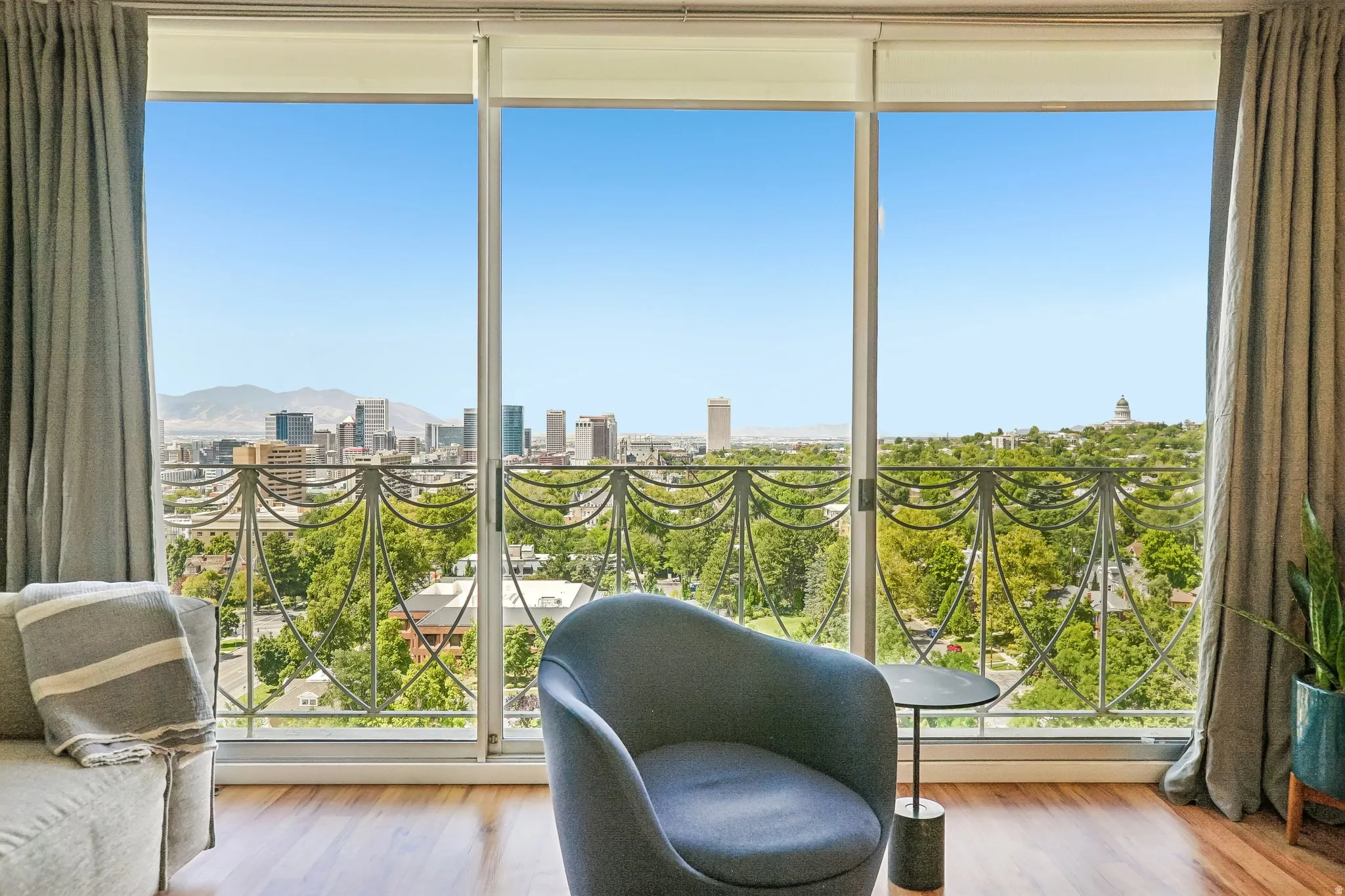 Hardwood-finish flooring, full-height sliding glass balcony doors, and decorative metal balcony railing