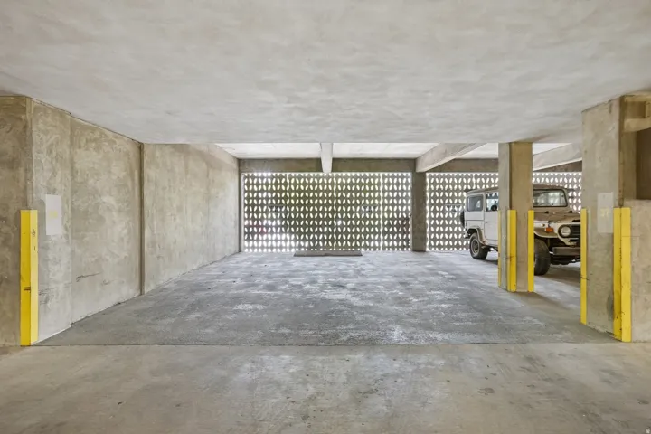 Concrete flooring with textured ceiling, concrete support columns, and perforated block wall