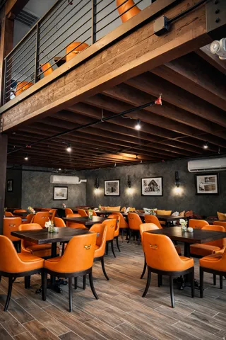 Exposed wood-beam ceiling, wood-finish flooring, textured wall finish, and a lofted area with metal railing