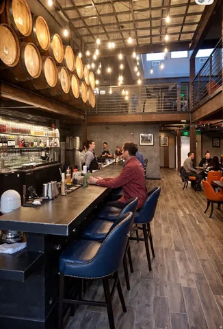 Exposed ceiling grid with pendant lighting, wood-finish flooring, and a two-story interior layout