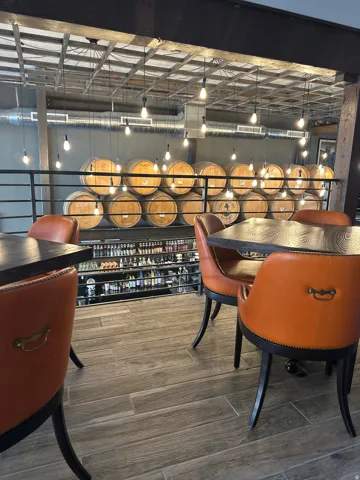 Exposed ceiling with ductwork and suspended lighting, wood-finish flooring, and a metal railing