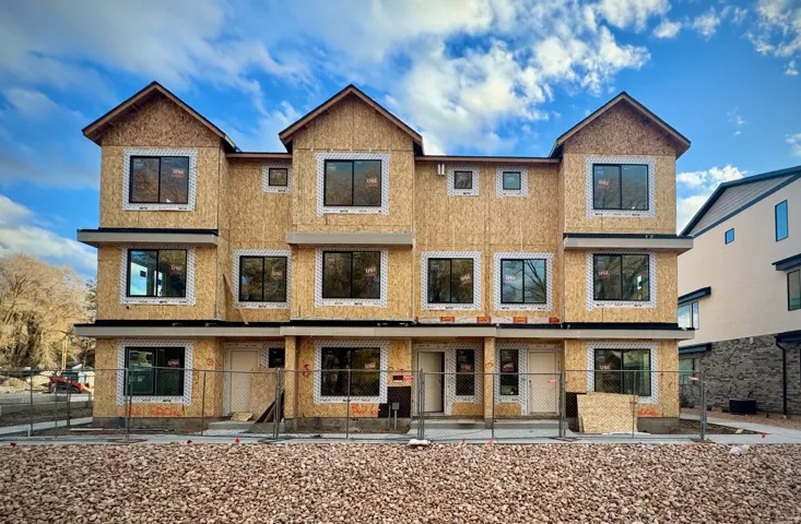 Three-story multiplex structure with multiple window units and individual entry doors