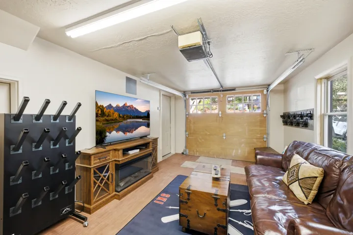 Recessed lighting, wood-finish flooring, garage door with upper window panels, and a side window