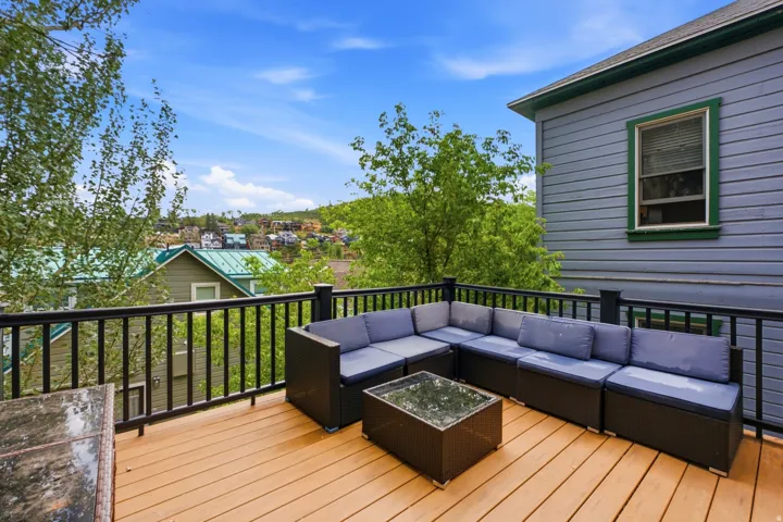 Expansive outdoor deck featuring wood-finish flooring and black metal railings