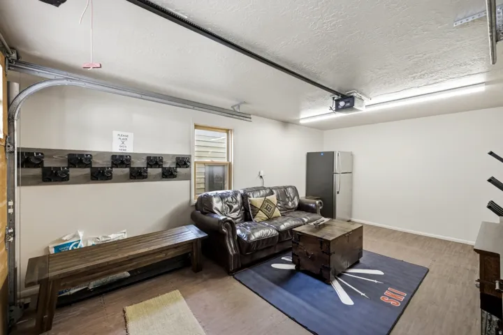 Garage space featuring wood-finish flooring, a built-in wall organizer, and a window for natural light