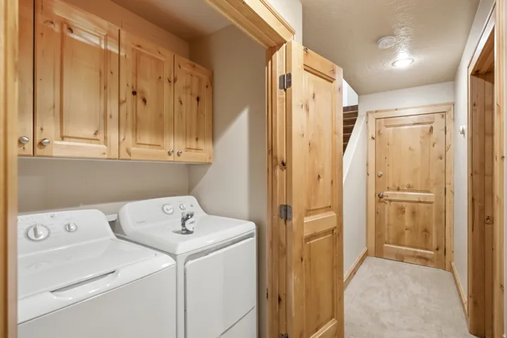 Laundry area featuring wood-finish cabinetry