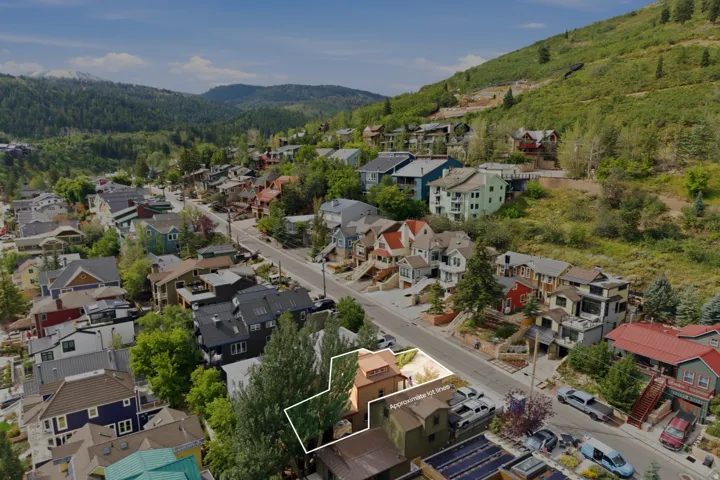 Elevated lot with mature trees and surrounding mountain terrain
