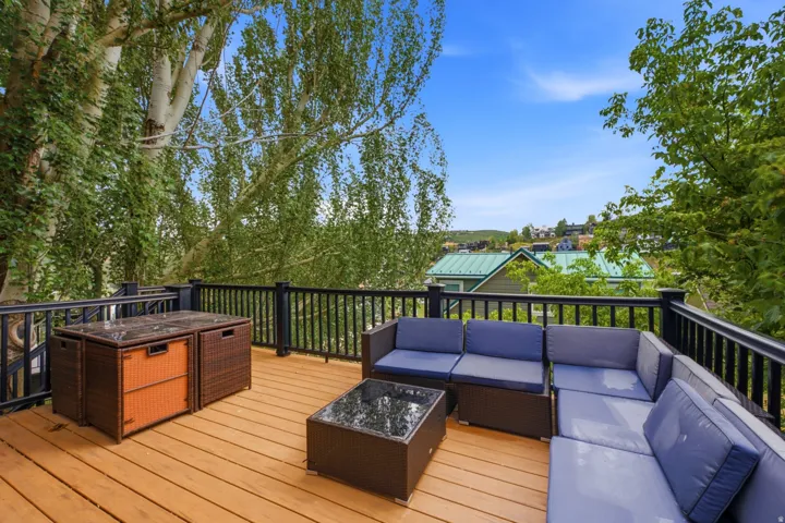 Expansive outdoor deck with wood-finish flooring and a black railing system