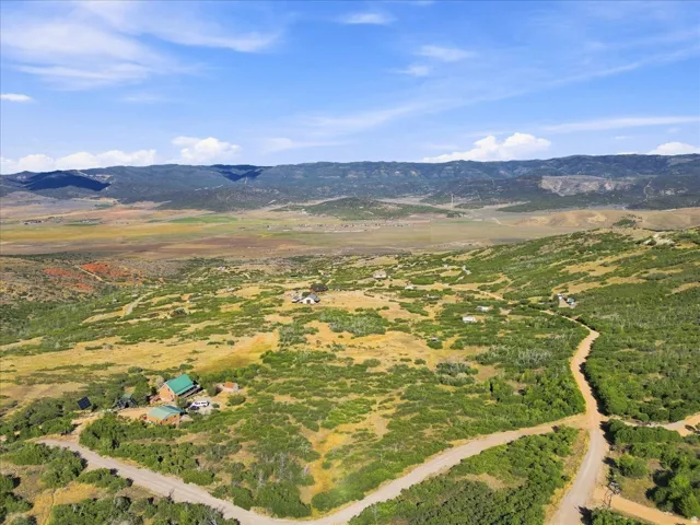 Expansive mountainous landscape featuring scattered residences and undeveloped land
