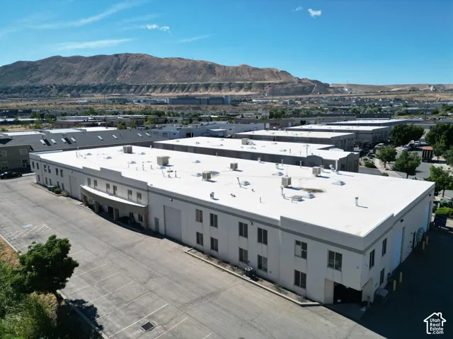 Industrial building with a large paved parking area, multiple loading dock doors, and a flat roof