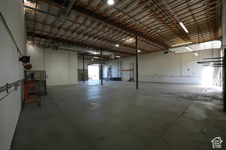 Spacious warehouse interior with concrete flooring and exposed beam ceiling
