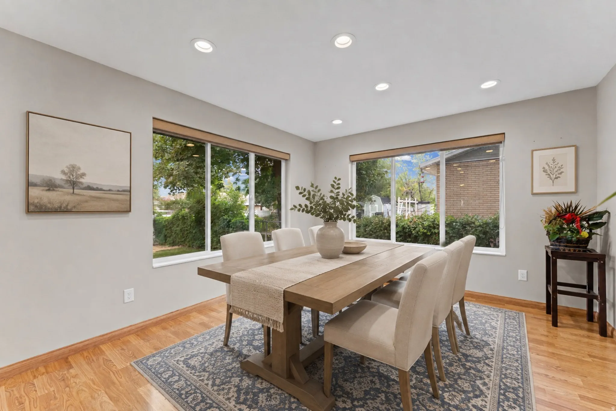 Recessed lighting, light gray wall finishes, wood-finish flooring, and expansive windows with natural light