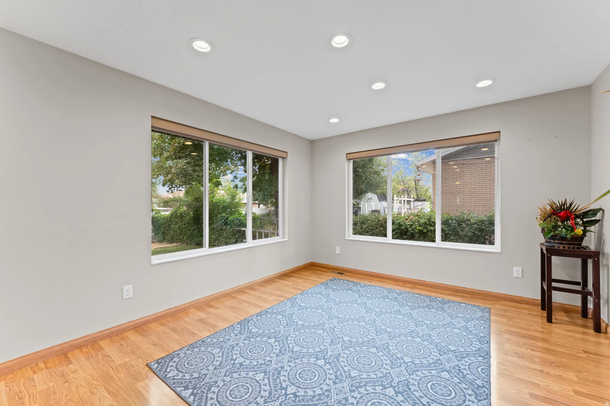 Recessed lighting, wood-finish flooring, and multiple windows providing natural light