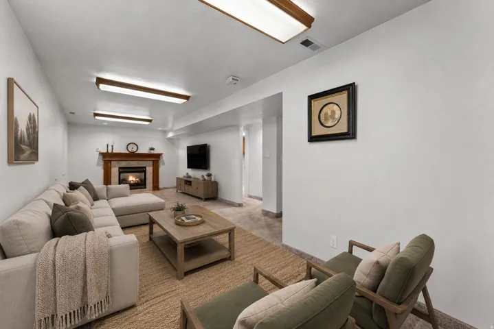 Recessed ceiling lighting, a fireplace with a wood mantel, light-toned wall finishes, and a tiled floor