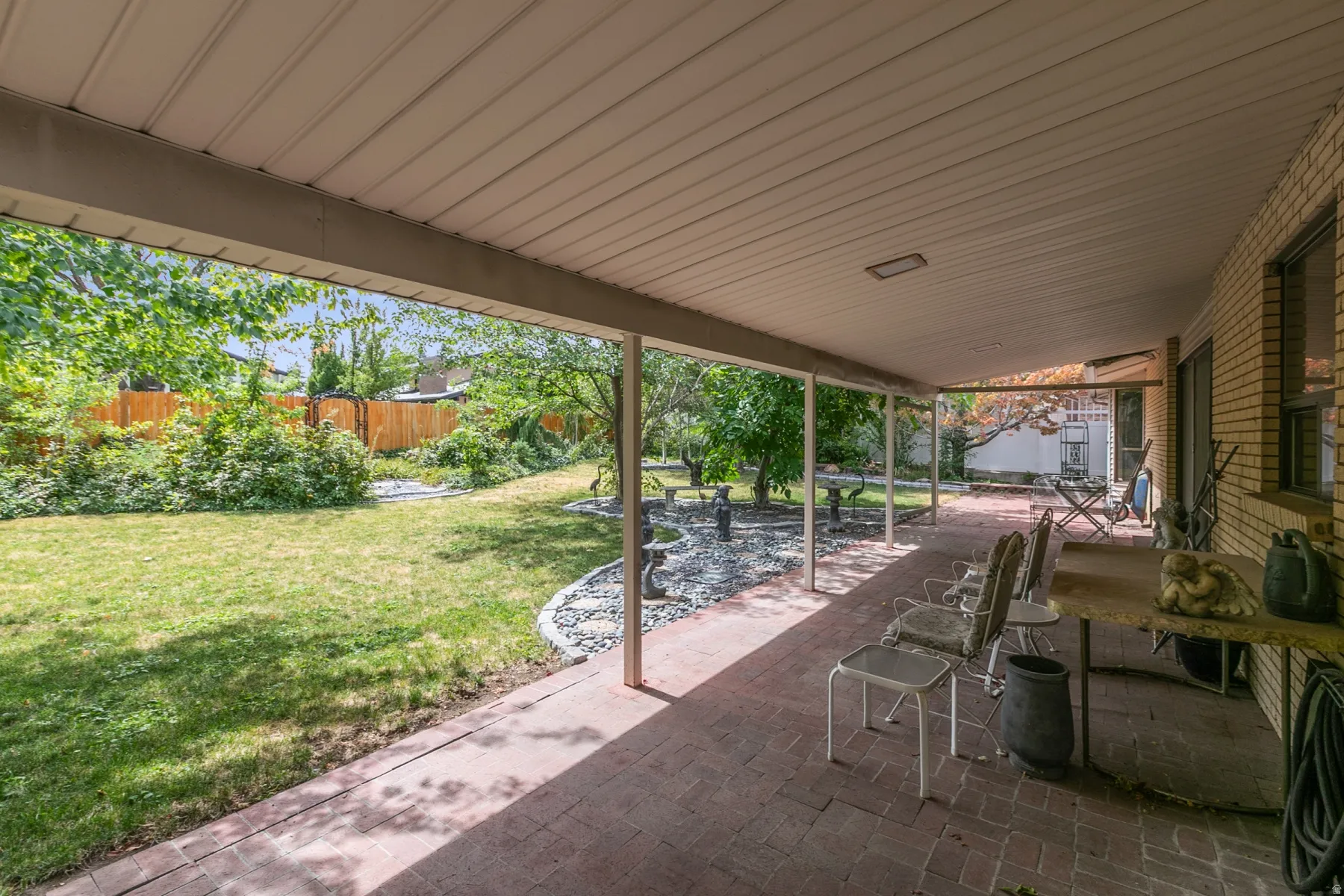Covered patio featuring a brick surface, white ceiling, and a supporting column